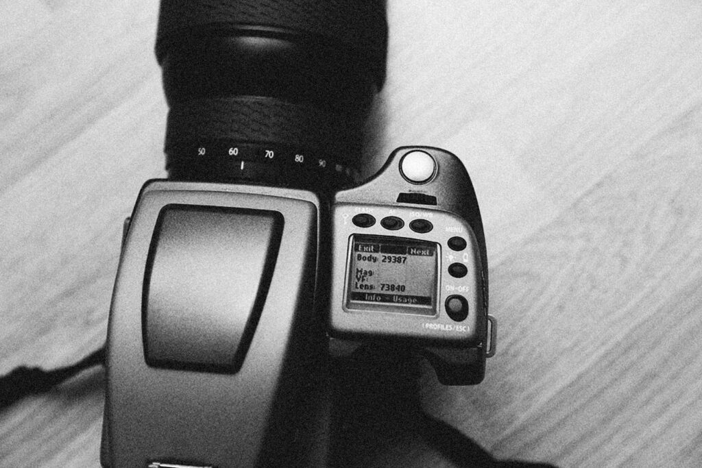 Monochrome image of a camera taken from above on a wooden floor.