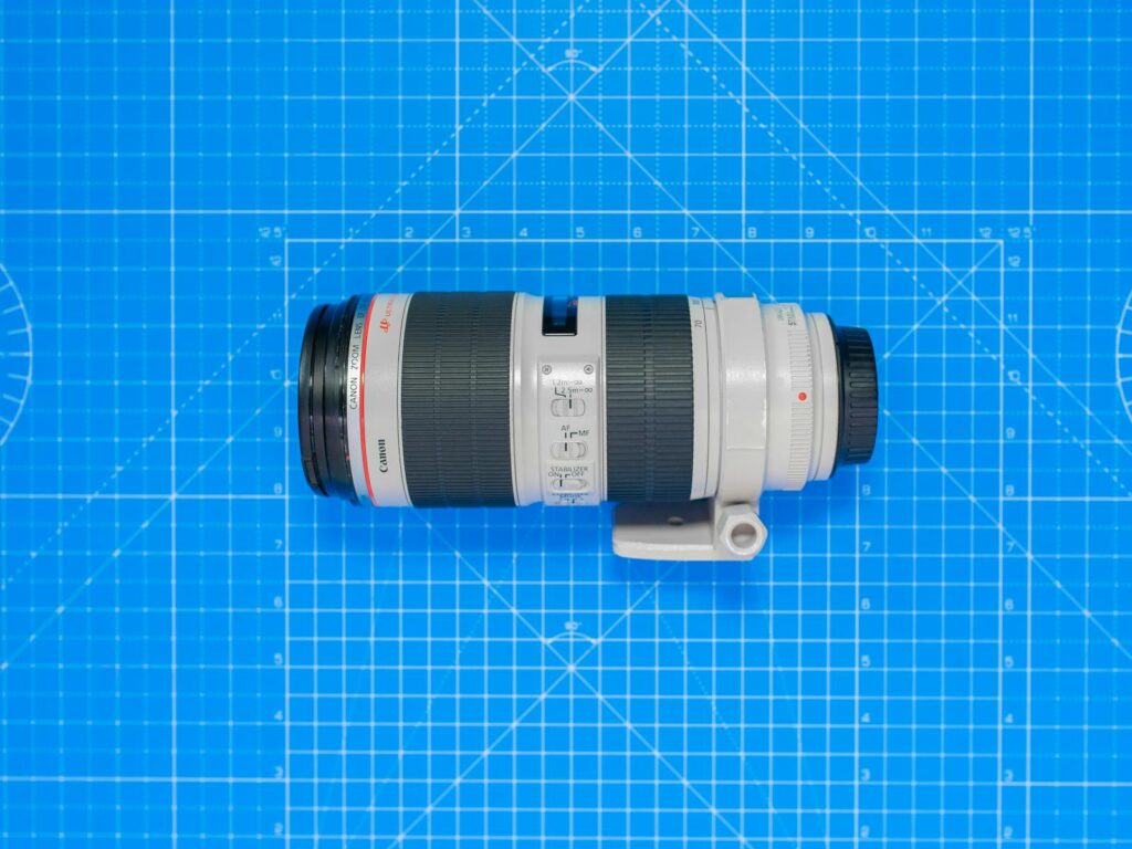 Top view of a professional camera zoom lens on a blue grid pattern background.
