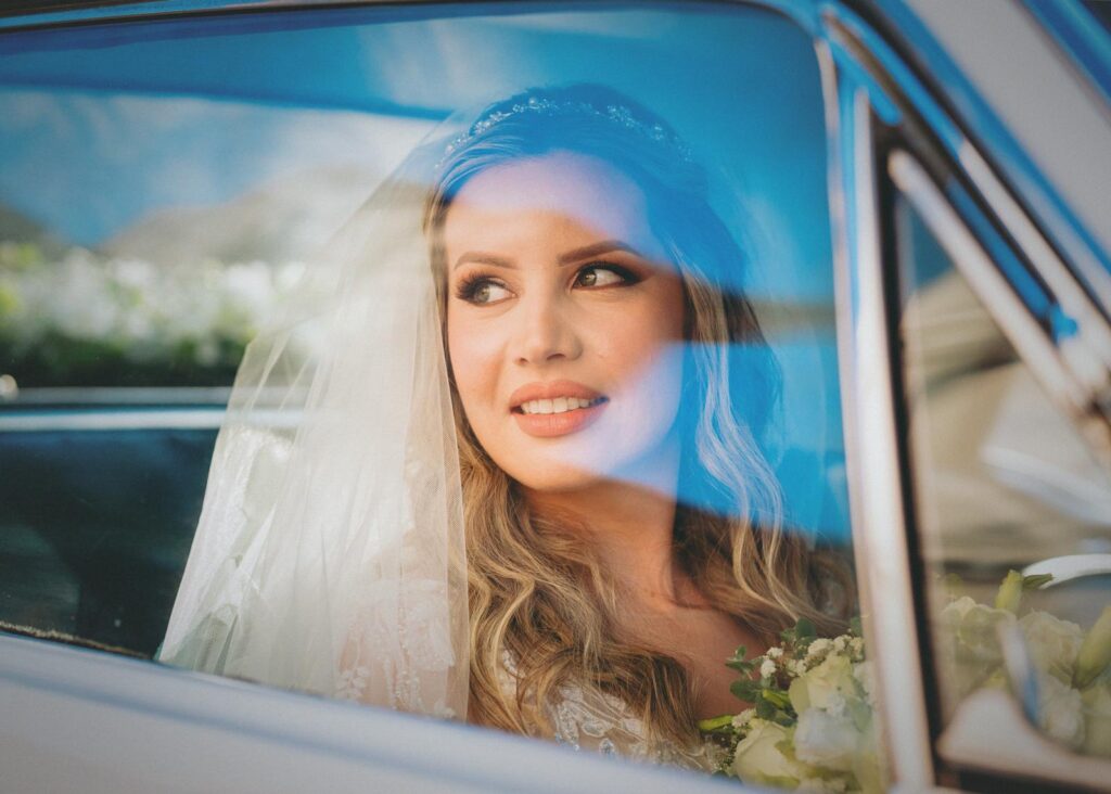 A joyful bride gazing out from a car window in Asunción, Paraguay.
