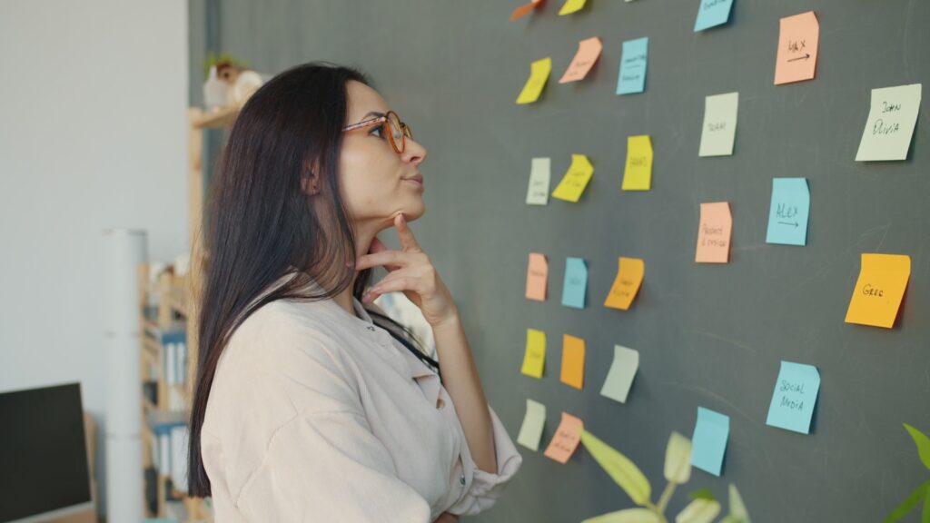 Woman looking at colorful sticky notes on wall